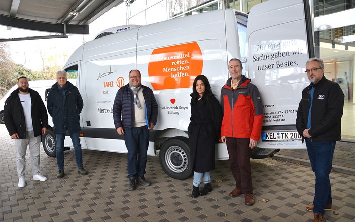 Mercedes-Benz Sprinter mit Aufdruck der Kehler Tafel vor dem S&G Standort in Kehl. Vorstand der Tafel sowie Mitarbeiter von S&G stehen vor dem Transporter